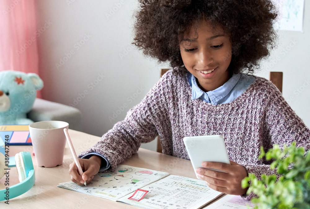 Teen studying math with phone and worksheet