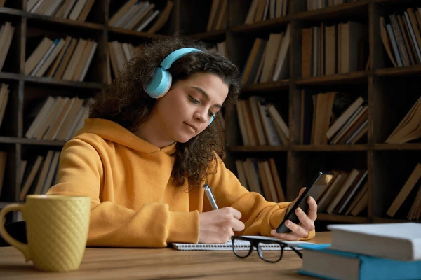 Student studying with headphones in library